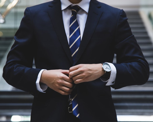 man buttoning his blue business suit